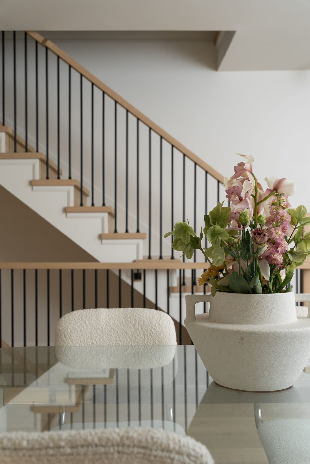 Custom oak staircase with black railings viewed from a renovated dining area